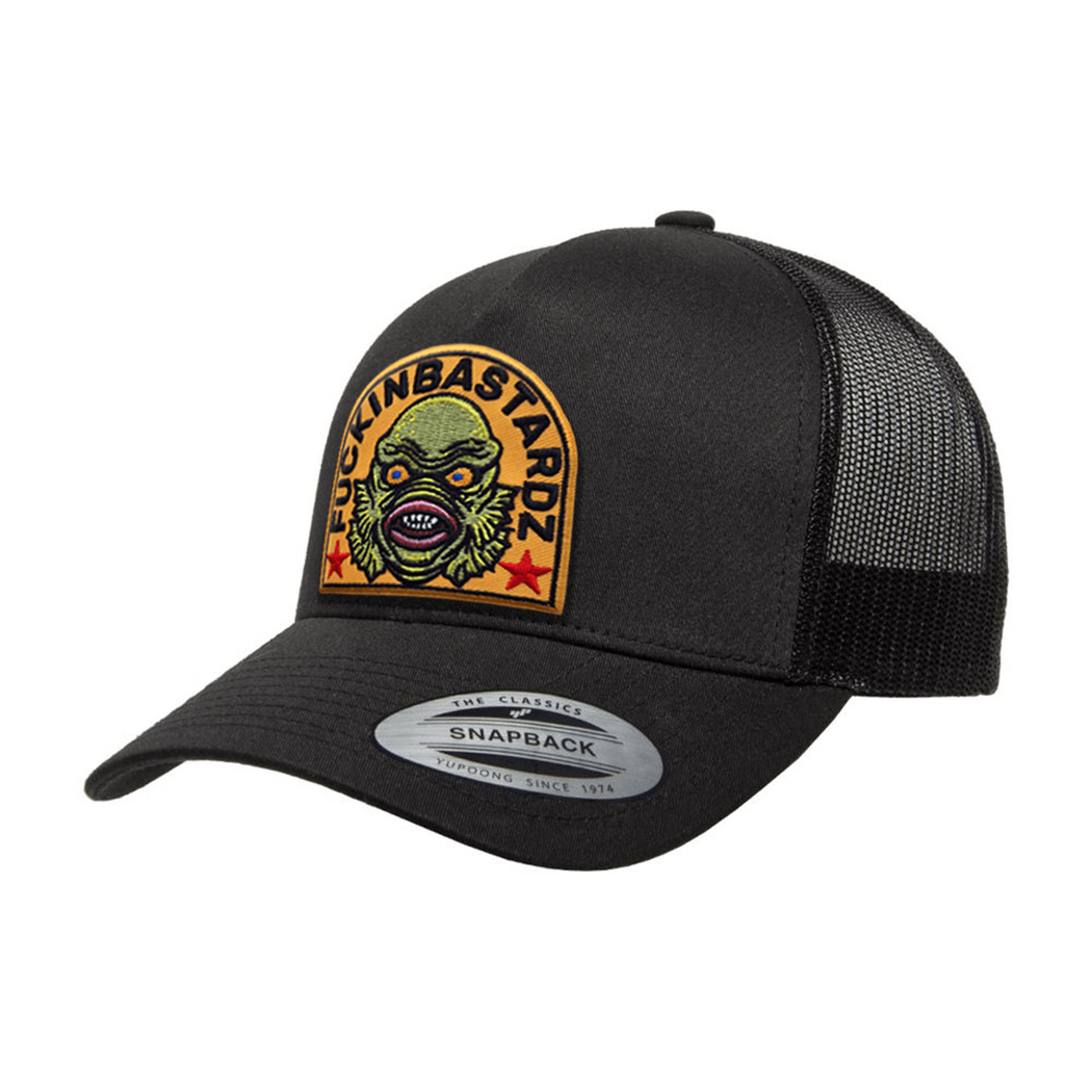 Creature of the Lagoon trucker cap featuring an embroidered patch on a black Yupoong snapback design.